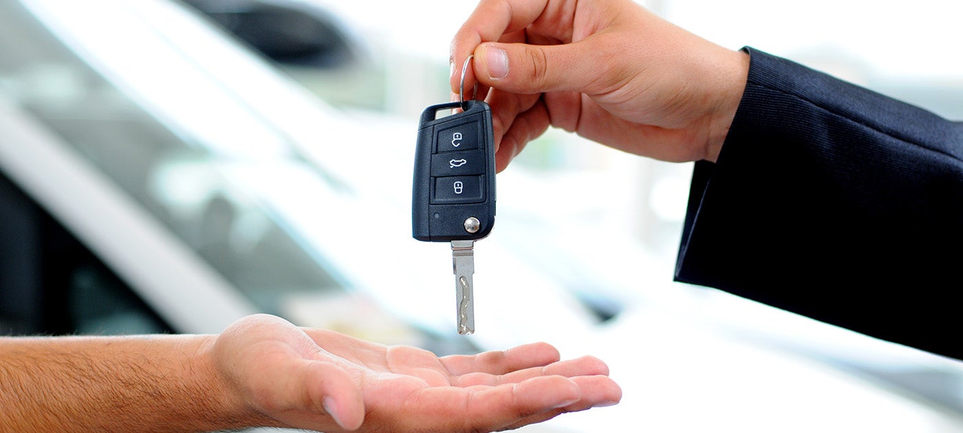 man giving car keys to other